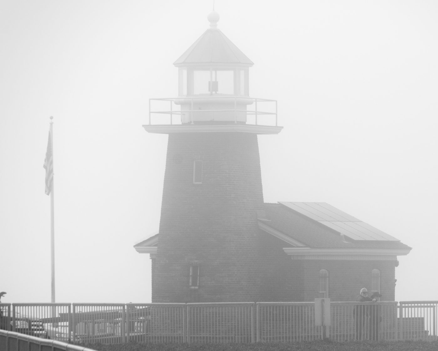 The brick Mark Abbott Memorial Lighthouse and its pale lantern in thick fog at Lighthouse Point, Santa Cruz.